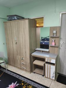 a room with wooden cabinets and a desk at Spacious Studio with Private kitchen near Skytrain in Bangkok