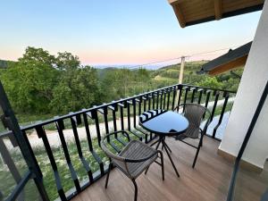 a table and chairs on a balcony with a view at Cabana Brad Apuseni Villa in Cotorăşti
