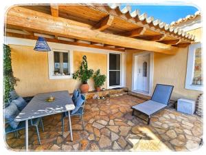 a patio with a table and chairs on a stone patio at Petit paradis grec in Loukaḯtion