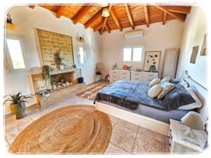 a bedroom with a large bed and a fireplace at Petit paradis grec in Loukaḯtion