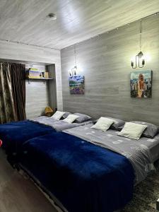 a bedroom with two large beds with blue sheets at Mi home in Chişinău