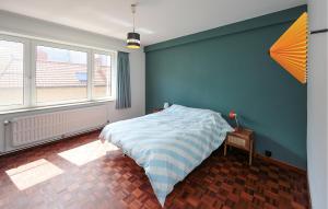 a bedroom with a bed with a blue wall at 3 Bedroom Nice Apartment In Oostende in Ostend