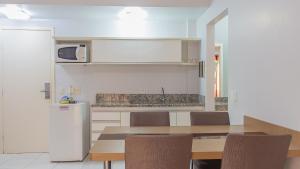 a kitchen with a table and chairs and a refrigerator at Lagoa Quente Hotel - LAGOA OFICIAL in Caldas Novas