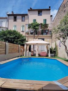 a large blue swimming pool with an umbrella at Maison chez Marthe in Le Muy