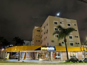 a building with a store in front of it at night at Afford Hotéis in Lages