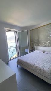 a bedroom with a bed and a large window at Lake Mirror in Lezzeno