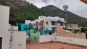a group of buildings in front of a mountain at Dheeksha Homestay in Tiruvannāmalai