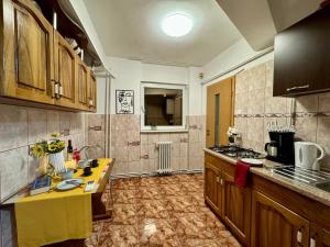 a kitchen with wooden cabinets and a yellow counter at Joy City Stay Ultracentral in Timişoara