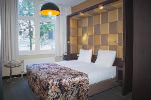 a hotel room with a bed and a large window at Golden Mansion Aparthotel in Amsterdam