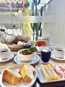 a table with plates of bread and other foods at Casa Dos Gringobz in Búzios +19 photos