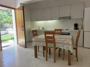 a kitchen with a table and chairs and a stove at Grammatoula Apartment in Nikiana