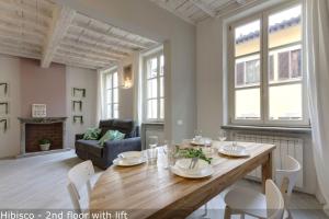 a living room with a wooden table and chairs at Mamo Florence - Vertical Garden Apartments in Florence