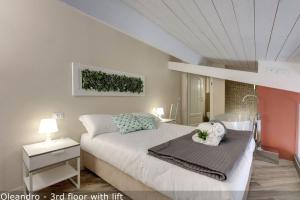 una camera da letto con un letto bianco con un dipinto sul muro di Vertical Garden Apartments by Mamo Florence a Firenze