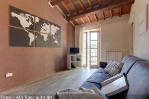 a living room with a blue couch and a world map on the wall at Mamo Florence - Vertical Garden Apartments in Florence