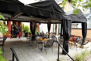 a black umbrella on a patio with tables and chairs at Hôtel Le Germain Québec in Quebec City