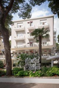 a white building with a sign in front of it at Hotel Plaza in Milano Marittima