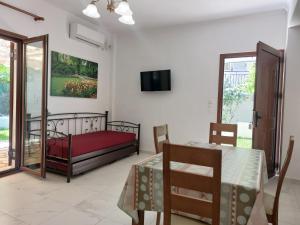 a bedroom with a bed and a table and a television at Grammatoula Apartment in Nikiana
