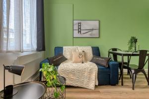 a living room with a blue chair and a table at Le Doux Refuge in Calais
