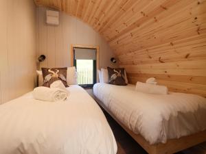 two beds in a log cabin with a window at Oyster Catcher in Carnforth