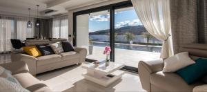 a living room with a couch and a large window at Luxury Villa Milly Heated indoor and outdoor pool in Vrh