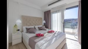 a white bedroom with a large bed with pink flowers on it at Luxury Villa Milly Heated indoor and outdoor pool in Vrh +10 photos
