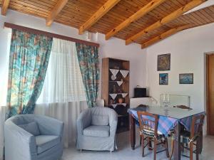 a living room with a dining room table and chairs at Eve's house in Mokhós