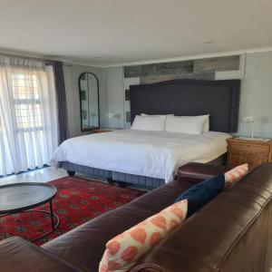 a bedroom with a large bed and a couch at Palm Bliss Self Catering Accommodation in Durban