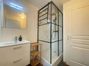 ein Badezimmer mit Glasdusche und Waschbecken in der Unterkunft Au bord de mer in Saint-Benoît-des-Ondes