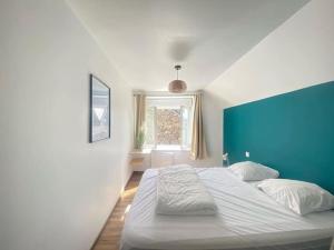 ein Schlafzimmer mit einem großen Bett mit einer blauen Wand in der Unterkunft Au bord de mer in Saint-Benoît-des-Ondes