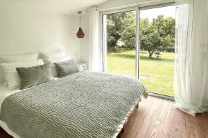 a bedroom with a bed and a large window at Chez Josie, cottage en Bretagne in Bannalec