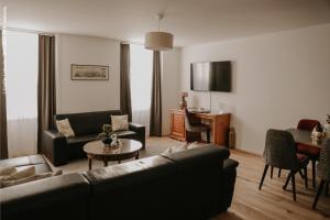 沙尔梅Résidence le Sapin & Bains de la Gruyère的带沙发和桌子的客厅