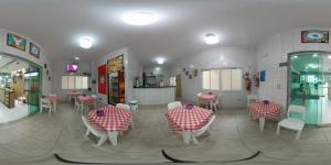 a dining room with red and white tables and chairs at Costa Sol Pousada in Praia Grande