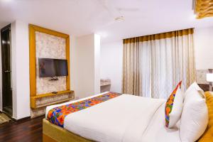 a hotel room with a bed and a tv at FabHotel WR Grand- Nr Citi Neuro Centre- Banjara Hills in Hyderabad