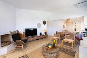 a living room with a couch and a table with a tv at Quinta do Lago Luxury Beach Apartment in Almancil