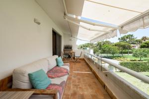a living room with a couch on a balcony at Quinta do Lago Luxury Beach Apartment in Almancil