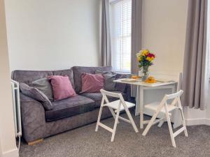 a living room with a couch and a table with chairs at North Lodge Retreat Allonby in Maryport