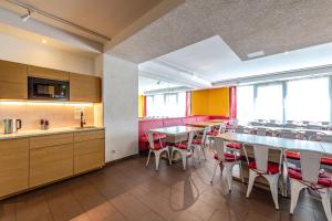 a restaurant with tables and chairs and a kitchen at A&T Hotel & Hostel in Vienna