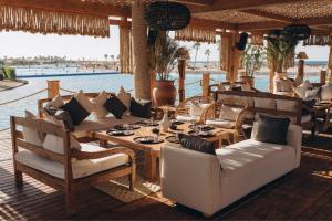 a restaurant with a table and chairs and a pool at Le Sidi - A TLT Signature Hotel in El Alamein