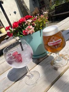 two glasses of beer and a vase with flowers at Hare and Hounds in Foulridge