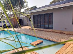 a swimming pool in front of a house at CozyNest in Margate
