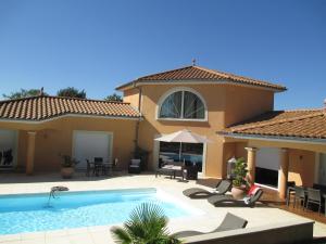 uma villa com uma piscina e uma casa em Le Mas du Fort em Neyron