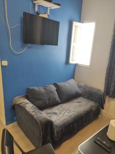 a living room with a couch and a flat screen tv at Paris apertment in Paris