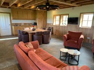 a living room with a couch and chairs and a table at Erve Schuurboer in Tilligte