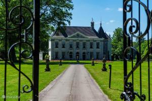 an entrance to a large white house with a driveway at Erve Schuurboer in Tilligte