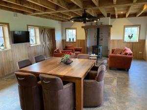 a living room with a wooden table and chairs at Erve Schuurboer in Tilligte