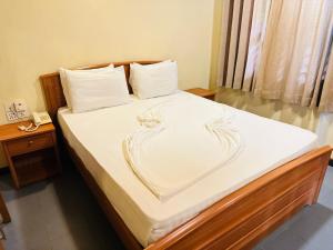a bedroom with a bed with white sheets and a heart at Gamodh Citadel Resort in Anuradhapura