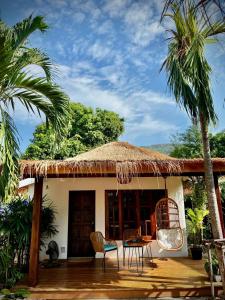 a small house with a thatched roof and a patio at PaChaSi Samui Bungalows in Ban Bang Po