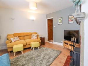 un soggiorno con un divano e una TV di Birch Cottage a Skipton