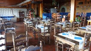 a dining room with tables and chairs with blue napkins at Hotel Terralta in Campelles