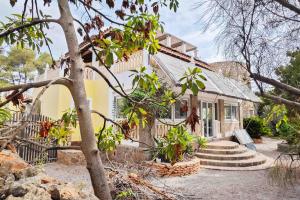 una casa amarilla con escaleras delante en Villa Tamaris, en Santa Eulària des Riu